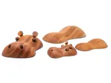 Fire træfigurer formet som flodheste, der er delvist nedsænket i vand, med glatte, afrundede træk og synlige øjne og næsebor.