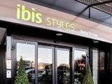 Indgang til Ibis Styles Roma Vintage hotel med glasdøre, to potteplanter og hotellets navn over indgangen.