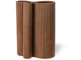 En høj, moderne brun vase med en bølget, organisk form og lodrette riller, som ligner kanelstænger, der står oprejst.