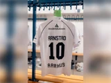 En hvid Aarhus-fodboldtrøje med nummer 10 og navnet Arnstad på ryggen, der hænger i et omklædningsrum.