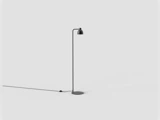 En minimalistisk sort gulvlampe med et slankt ben og en lille, afrundet lampeskærm på en cirkulær fod.