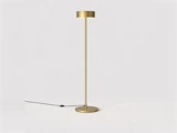 Minimalistisk gulvlampe i guld med en slank stamme samt en cirkulær fod og lampeskærm.