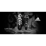 To sorte og hvide Adidas-fodboldstøvler med slangeskindsmønster vises side om side på en sløret baggrund med Adidas-logoet og Limited Collection-teksten til venstre.