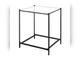 Et lille, firkantet sidebord med en bordplade af klart glas og et minimalistisk stel af sort metal.