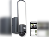 En moderne vægmonteret udendørs sikkerhedslampe med indbygget kamera, vist ved siden af en smartphone, der viser et live videofeed og optagemuligheder.