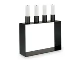 En moderne sort, rektangulær lysestage med fire hvide, cylindriske lys, der står lodret på toppen.