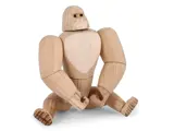 En gorillafigur i træ med leddelte lemmer, der sidder med spredte ben og bøjede arme, med en lys træfinish og enkle ansigtsdetaljer.