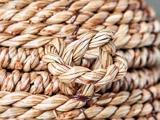 Nærbillede af et snoet, tykt flettet reb af naturfibre, der viser en markant løkke og en detaljeret vævet struktur.