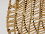 Nærbillede af en kurv vævet af rattan eller pil, der viser det detaljerede vævemønster samt de naturlige, lysebrune og brune farver.