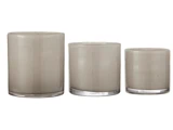 Tre cylindriske glasbeholdere i forskellige højder, alle i en lysebrun eller taupe farve, er arrangeret side om side på en hvid baggrund.
