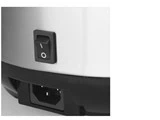 Nærbillede af en sort tænd/sluk-knap med I/O-symboler på et sølv- og sort elektronisk apparat, placeret over en rektangulær stikkontakt.