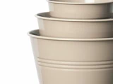 Fire beige plastikskåle, der er indlejret i hinanden, set fra siden mod en hvid baggrund.