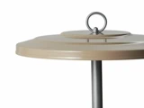 Nærbillede af et beige metal låg med et rundt håndtag på toppen, fastgjort til en lodret sølvstang, på en hvid baggrund.