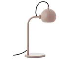 En moderne pink skrivebordslampe med rund fod, buet hals og kuppelformet skærm. En sort netledning går ud fra foden.