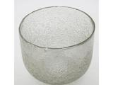 En gennemsigtig glasskål med en struktureret, boblende overflade mod en almindelig hvid baggrund.