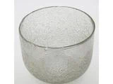 En gennemsigtig glasskål med en struktureret, boblende overflade mod en almindelig hvid baggrund.