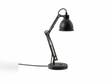 En sort, justerbar bordlampe med en rund fod, synlige fjedre og en kuppelformet lampeskærm, fotograferet på en ensfarvet hvid baggrund.