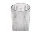 Et klart glas med lodrette, strukturerede riller, vist mod en hvid baggrund.