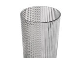En klar glasbeholder, hvor den ene halvdel har lodrette riller og den anden halvdel er dækket af små, hævede prikker.