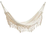En cremefarvet hængekøje med dekorative frynser, der hænger i reb i begge ender, isoleret på en hvid baggrund.