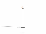 Minimalistisk gulvlampe med et tyndt sort stativ og en kugleformet hvid glasskærm.