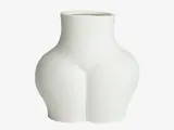 En hvid keramikvase, der er formet som en menneskelig torsos kurver og har glatte og minimalistiske linjer.