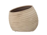 En beige, riflet keramikpotte med en skrå, oval åbning, placeret på en hvid baggrund.