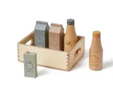 En legetøjskasse af træ indeholder legetøjskartoner mærket mælk, chokolademælk, æblejuice og to flasker mærket æble og appelsin, alt sammen i neutrale farver på en hvid baggrund.