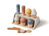 Legetøjsissæt i træ med stabelbare kugler, vafler og tænger på et lille træstativ mod en hvid baggrund.