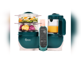En blågrøn Babymoov Nutribaby-foodprocessor med stablede dampbakker med grøntsager og et blenderrum fyldt med appelsinpuré.