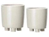 To beige keramikpotter med tre korte ben hver, udstillet side om side, en større og en mindre.