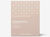 En beige æske med mærket SKANDINAVISK ROSENHAVE duftlys, med hvide minimalistiske symboler og en tekst, der beskriver det som et blomsterhelligdom lavet med svensk rapsolie.