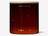 En mørk ravfarvet glaskrukke med trælåg og minimalistisk guldtekst med teksten SKANDINAVISK og TAKKA samt små guldstjerner og kors.