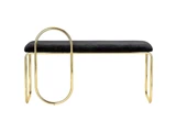 En moderne bænk med sort polstret sæde og guldfarvet metalstel med en unik stor oval sløjfe på den ene side som et dekorativt ben.