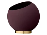 En rund, mørklilla vase med skrå åbning står på en guldmetallic base mod en hvid baggrund.