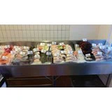 En fiske- og skaldyrsvitrine fyldt med forskellige friske fisk og skaldyr, alle med prisskilte, i et markedsmiljø med flisebelagte vægge.