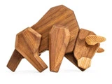 En geometrisk træskulptur af en tyr med kantede former og en glat finish, der står på en hvid baggrund.
