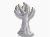 Hvid keramikskulptur, der ligner et abstrakt træ eller en hånd med flere udstrakte, afrundede grene eller fingre, placeret på en almindelig baggrund.