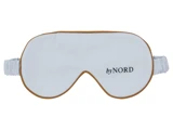 En hvid sovemaske med brun kant og elastik, med teksten by NORD på højre side.