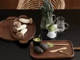 Et træbord med østershatte, avocadoer, matchapulver, matchadrik, træredskaber og glaskander med vand og bladgrønt.