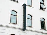 Hotel Phønix-skilt på en hvid bygning med buede vinduer.