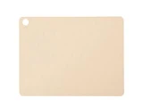 Beige rektangulært skærebræt med afrundede hjørner, et hul i øverste venstre hjørne og et mønster af små hævede cirkler på tværs af overfladen.