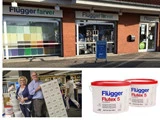 En farvehandel ved navn Flügger farver med farveprøver i vinduet, personale med malergrej og to Flügger Flutex 5 malerspande.
