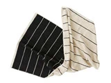 To rektangulære håndklæder, et sort med hvide striber og et beige med sorte striber, lagt overlappende på en hvid baggrund.