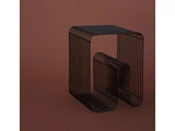 Et sidebord i sort metaltråd med et geometrisk, rektangulært design på en almindelig brun baggrund.