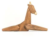 En minimalistisk træskulptur af en giraf lavet af enkle geometriske former, set fra siden, på en hvid baggrund.