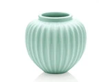 En lyseblågrøn keramikvase med lodrette riller og en bred, rund krop på en hvid baggrund.