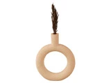 En beige, rund keramikvase med en hul midte og en smal hals, der holder en enkelt tørret, brun græsstængel.