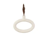 En minimalistisk hvid cirkulær vase med et enkelt tørret brunt siv placeret i den lille åbning i toppen mod en almindelig hvid baggrund.