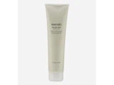 En beige tube mærket meraki AHA Body Scrub med en hvid flip cap, der står oprejst mod en almindelig hvid baggrund.